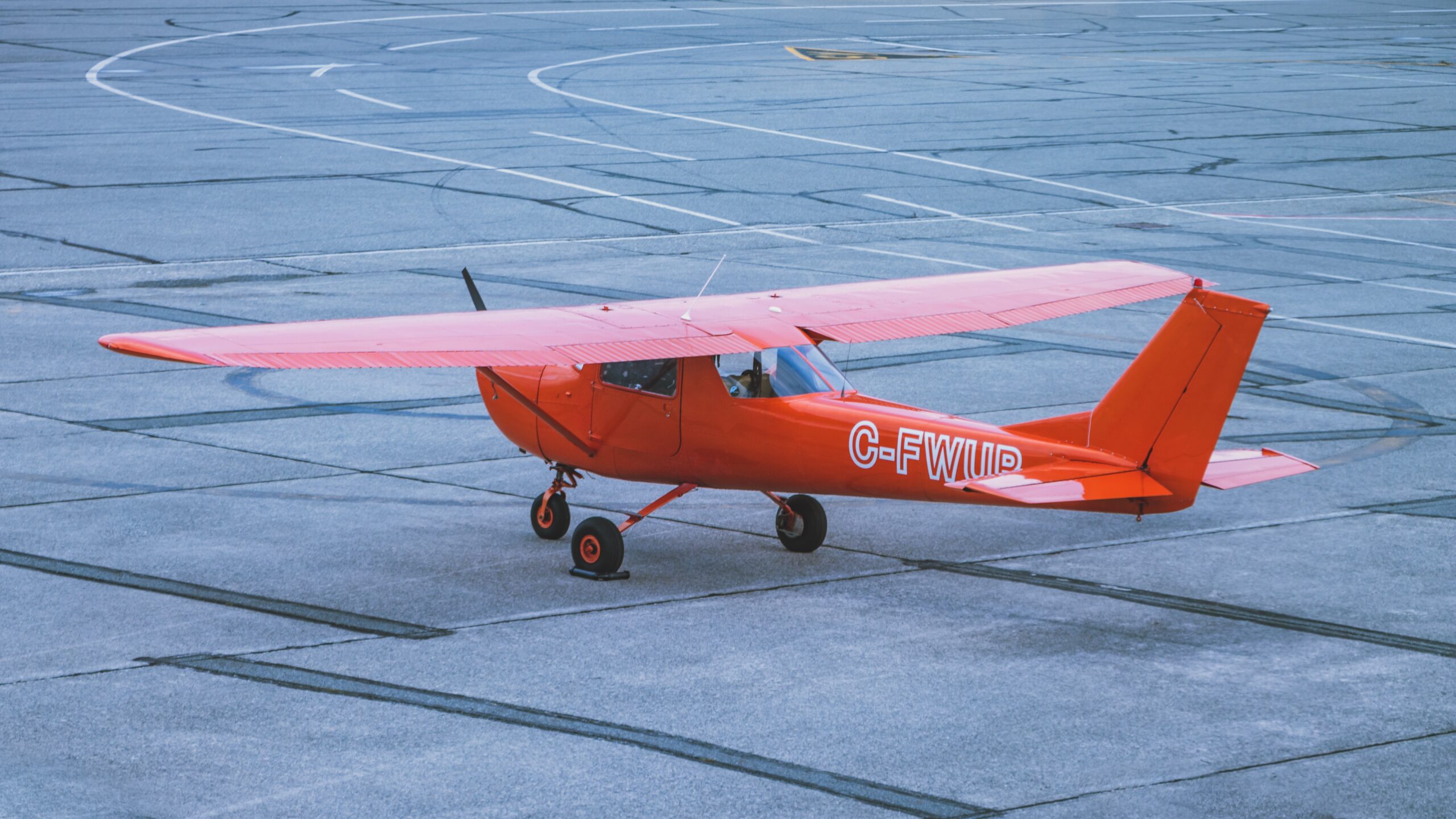 red and white airplane on gray concrete ground during daytime